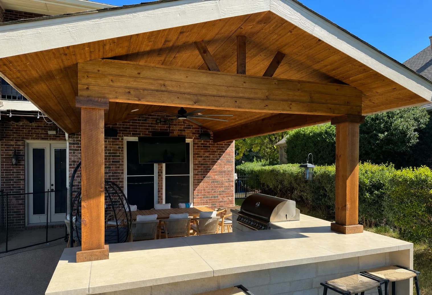 Cedar patio cover with exposed beams over a grill run.