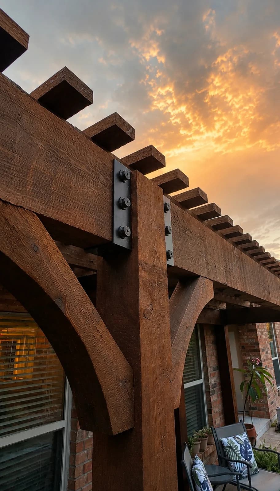 Steel bracket and cedar beam joinery against a sunset sky.