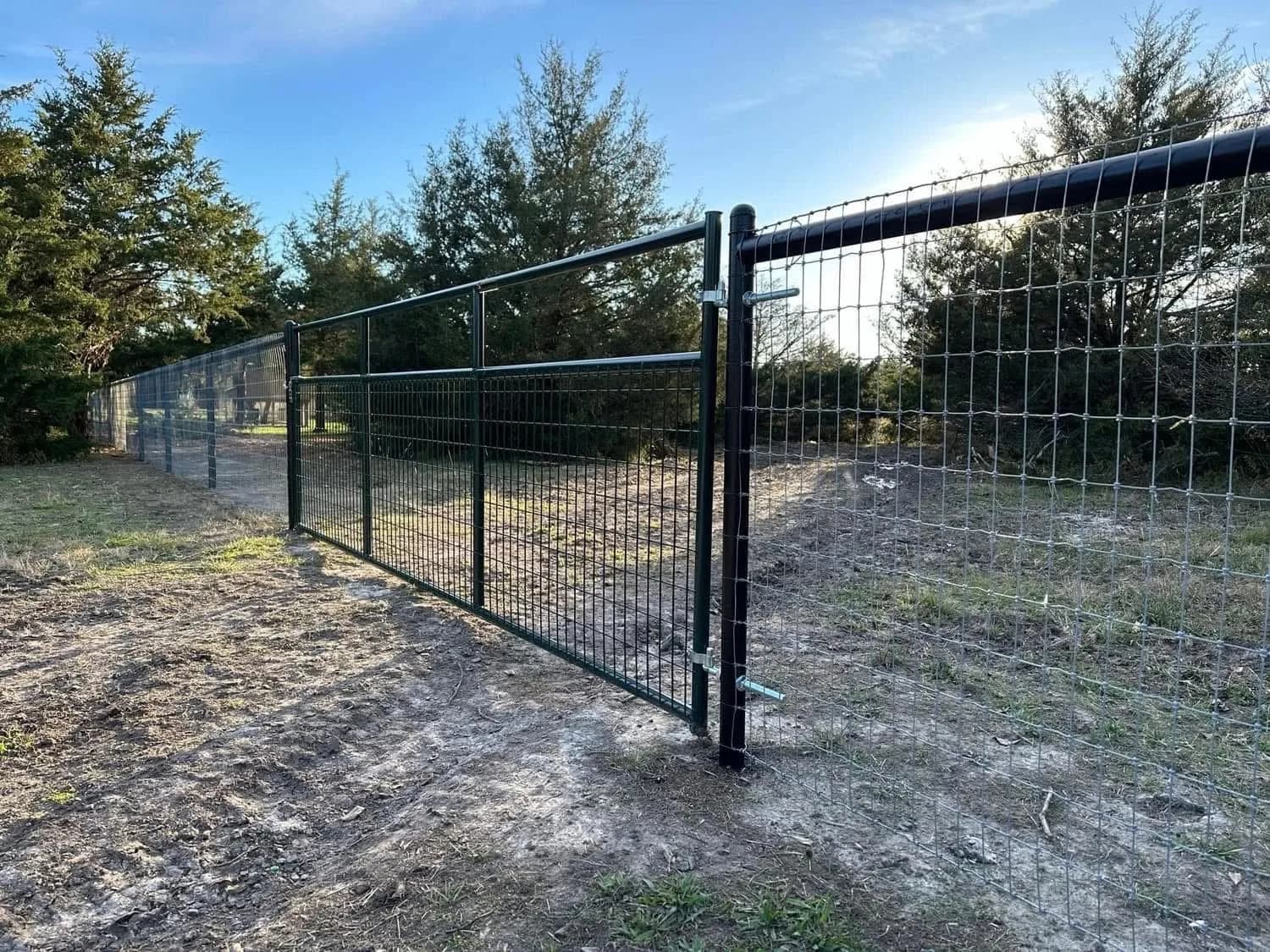 Welded wire gate hung on a painted pipe post.